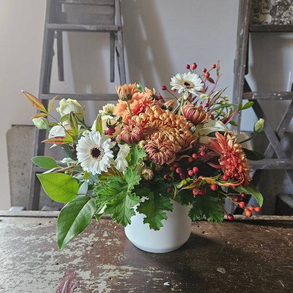 autumn colors arrangement in white ceramic vase