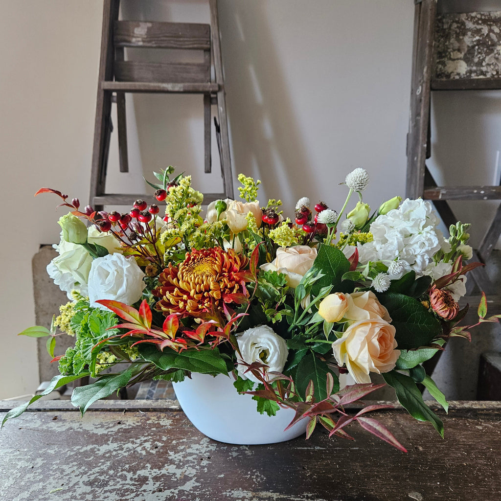 fall centerpiece in oblong white ceramic vase