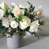 soft white and pale peach and pink flowers with greenery in ceramic vase