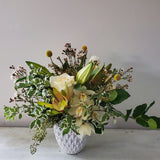 creamy whites and pale yellow flowers and greenery in ceramic vase
