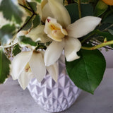 creamy whites and pale yellows with greenery and ceramic vase